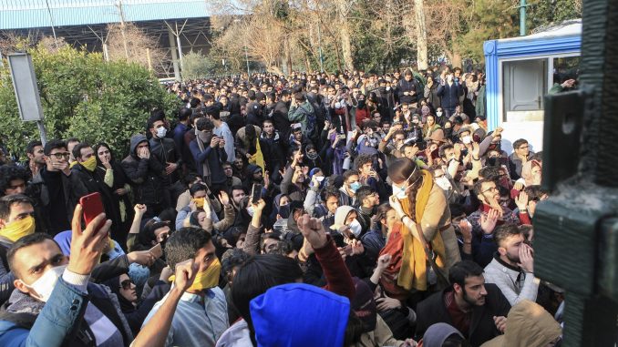 طلاب إيرانيون يحتجون داخل جامعة طهران في حين تعمل الشرطة الإيرانية لمكافحة الشغب على استخدام القنابل المسيّرة للدموع في طهران، إيران في 30 كانون الأول/ديسمبر 2017 (AFP) طلاب إيرانيون يحتجون داخل جامعة طهران في حين تعمل الشرطة الإيرانية لمكافحة الشغب على استخدام القنابل المسيّرة للدموع في طهران، إيران في 30 كانون الأول/ديسمبر 2017 (AFP)