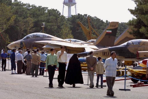 إيرانيون يجتازون طائرات حربية أميركية من طراز F-14 Tomcat و F-5E Tiger II أثناء زيارتهم لمعرض للطائرات العسكرية في طهران في 25 أيلول/سبتمبر 2002 (AFP) أف-14 تومكات