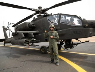فرد من القوات البرية الملكية السعودية من الكتيبة الأولى، مجموعة الطيران الثالثة، إلى جانب مروحية أباتشي قبل هجوم جوي عملي مع لواء الطيران القتالي 42 أثناء تمرين عسكري في 14 نيسان 2014 بالقرب من تبوك، المملكة العربية السعودية (صورة أرشيفية)
