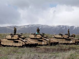 جنود إسرائيليون يقفون على دباباتهم المطلة على الحدود بين إسرائيل وسوريا. (رونين زفولون/ريوترز)