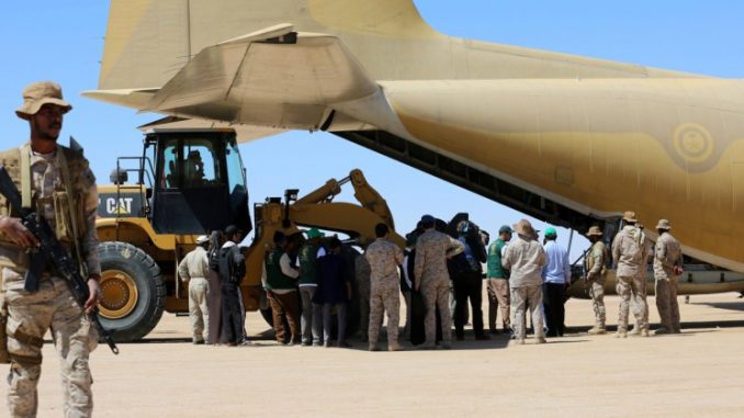 جنود سعوديون يقفون حراساً في حين يفرغ العاملون مساعدات من طائرة شحن تابعة لسلاح الجو السعودي في مطار في مأرب المركزي في اليمن في 8 شباط/فبراير 2018 (AFP)