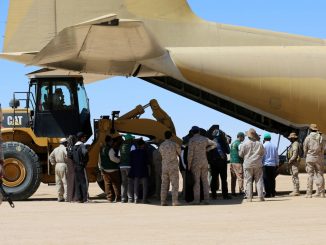 جنود سعوديون يقفون حراساً في حين يفرغ العاملون مساعدات من طائرة شحن تابعة لسلاح الجو السعودي في مطار في مأرب المركزي في اليمن في 8 شباط/فبراير 2018 (AFP)