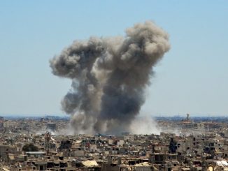 صورة تم التقاطها خلال جولة للحكومة بالقرب من حي القدم الجنوبي بدمشق، تُظهر دخاناً يتصاعد من المباني في مخيم اليرموك، وهو مخيم للاجئين الفلسطينيين على أطراف العاصمة، والمناطق المحيطة به، خلال قصف النظام الذي يستهدف جماعة الدولة الإسلامية (داعش) في 24 نيسان/أبريل 2018 (AFP)