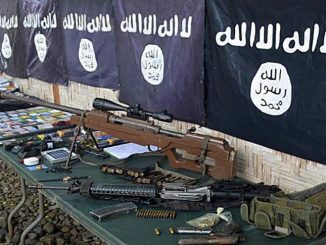 صورة تم التقاطها في 26 تشرين الثاني/نوفمبر 2015، تظهر فيها أسلحة وأعلام تنظيم داعش المستردة من أعضاء عصابة إجرامية تعهدت بالولاء لداعش في بلدة باليمبانج، إقليم سلطان كودارات، في جزيرة مينداناو الجنوبية (AFP)