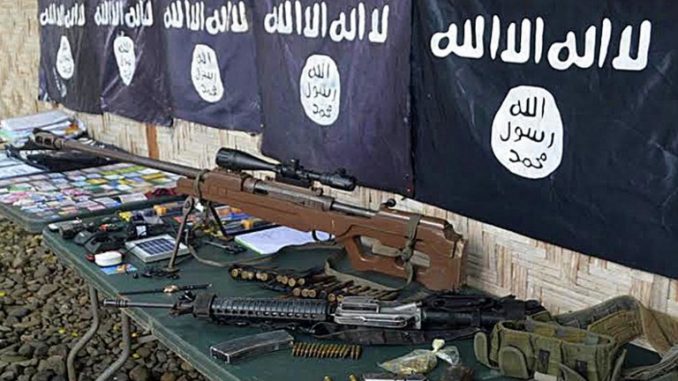 صورة تم التقاطها في 26 تشرين الثاني/نوفمبر 2015، تظهر فيها أسلحة وأعلام تنظيم داعش المستردة من أعضاء عصابة إجرامية تعهدت بالولاء لداعش في بلدة باليمبانج، إقليم سلطان كودارات، في جزيرة مينداناو الجنوبية (AFP)