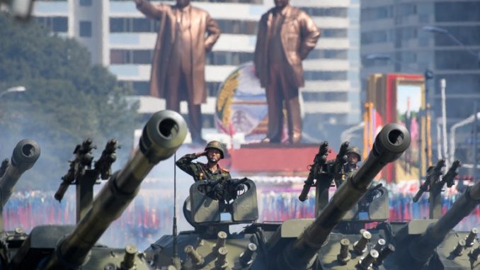 جنود الجيش الشعبي الكوري الشمالي يُلقون التحية أثناء جلوسهم في دبابات خلال استعراض عسكري ومسيرة حاشدة في ساحة كيم ايل سونغ في بيونغ يانغ يوم 9 أيلول/سبتمبر 2018 (AFP)