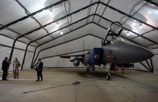 وزير الخارجية الأميركي السابق مايك بومبو ينظر إلى طائرة من طراز F-15E بينما كان يزور قاعدة الأمير سلطان الجوية في الخرج، وسط المملكة العربية السعودية في 20 شباط 2020 (AFP) مايك بومبيو